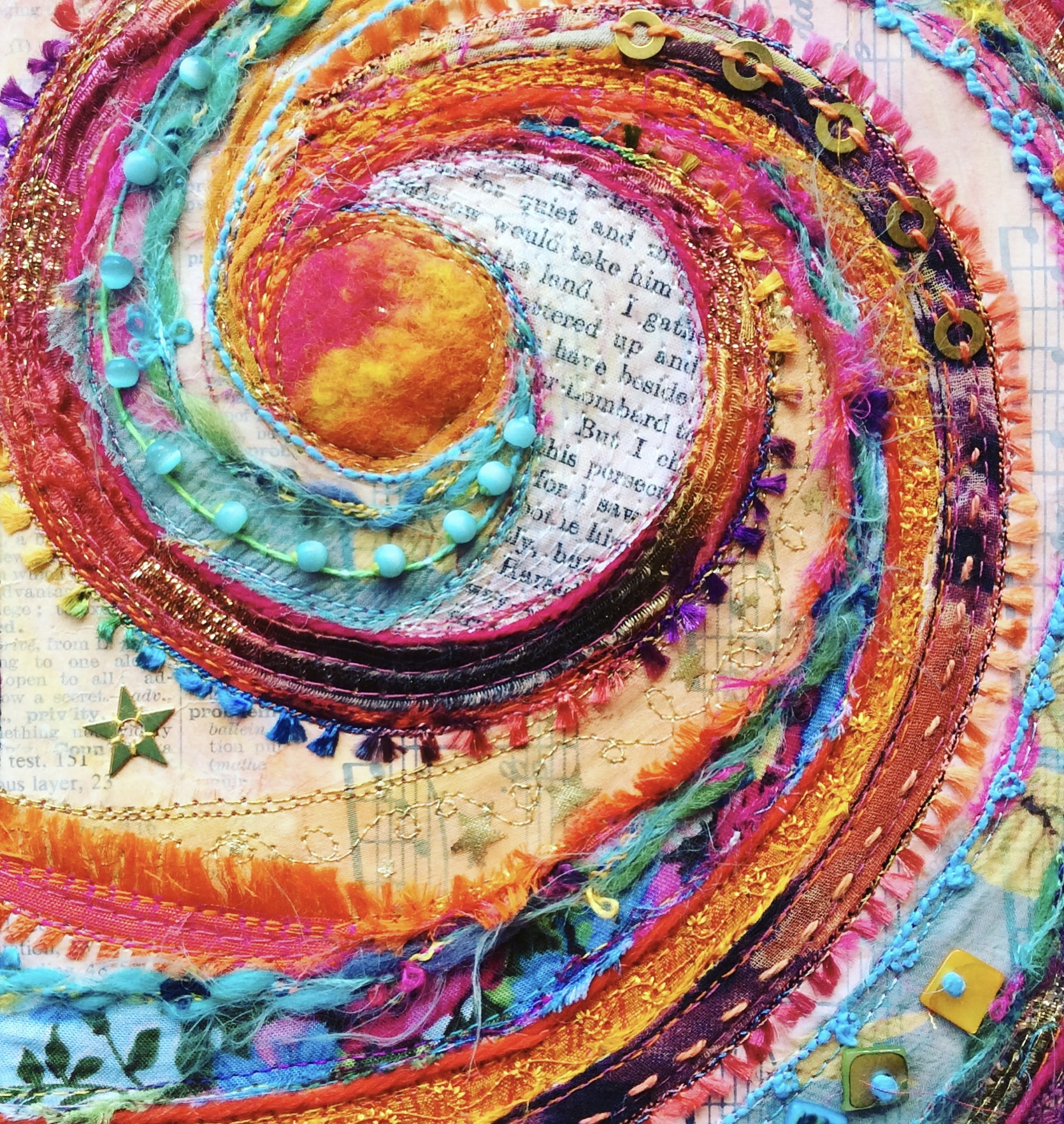 a spiral of multicoloured fabric, stitch and beads